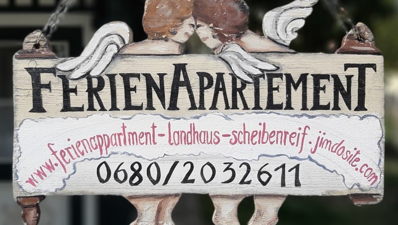Infotafel für Wanderer, © Karin Scheibenreif Holzschild mit der Aufschrift 'Ferienapartement' und zwei Engeln.