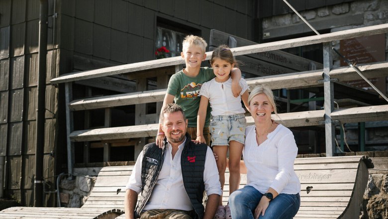 Fischerhütte, Schneeberg, Hut, Schneebergland, Vienna Alps in Lower Austria, © Wiener Alpen/Sophie Menegaldo A family is sitting on a wooden bench in front of the fisherman's cabin on Schneeberg