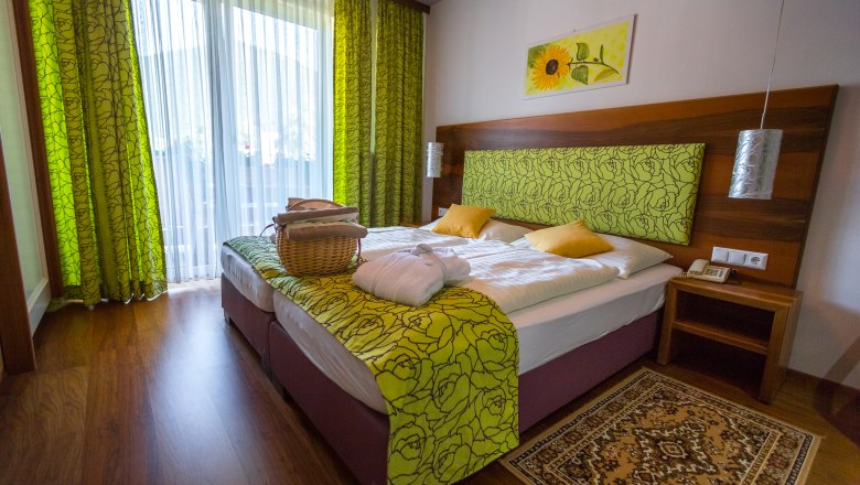 Double room, © Wiener Alpen / Christian Kremsl Room with double bed, wooden floor and green curtains