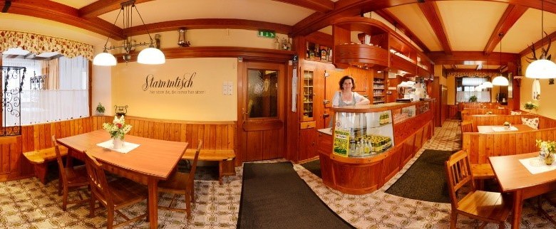 Restaurant, © Gasthof Schmirl Panorama of a cozy restaurant with wooden furniture and decorative lamps.