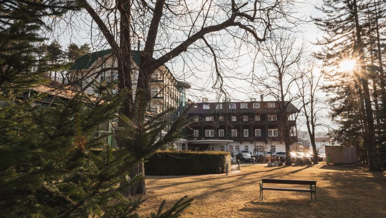 Schneeberghof Hotel, © Hotel Schneeberghof Hotel Schneeberghof in the sunlight with trees in the foreground.
