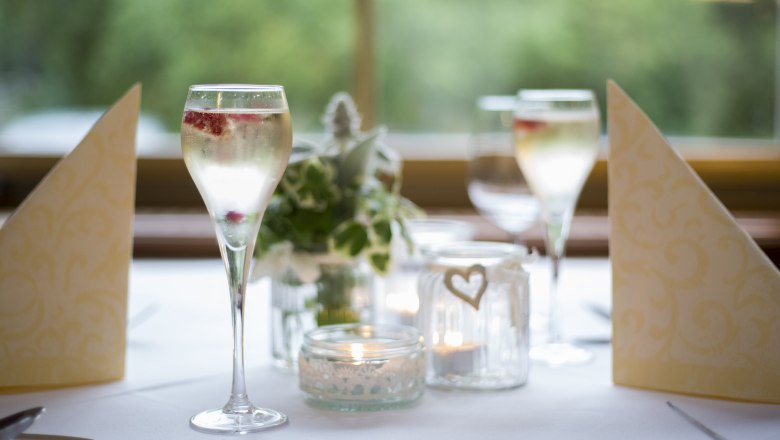 Alpen-Aktiv Country Inn "Zur Schubertlinde", © Patrick Haberler Elegant table decoration with champagne glasses, candles and napkins.