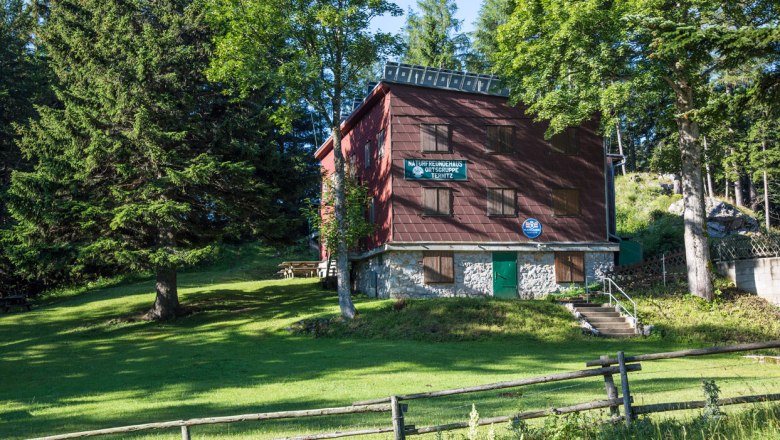Ternitzer Hut, © Wiener Alpen, Foto: Franz Zwickl A mountain hut surrounded by trees and meadows, with a wooden fence in the foreground.