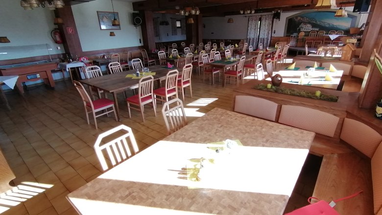 Dining room Gasthof Mohr, © Harald Mohr An empty dining room with wooden tables and red chairs at Gasthof Mohr.