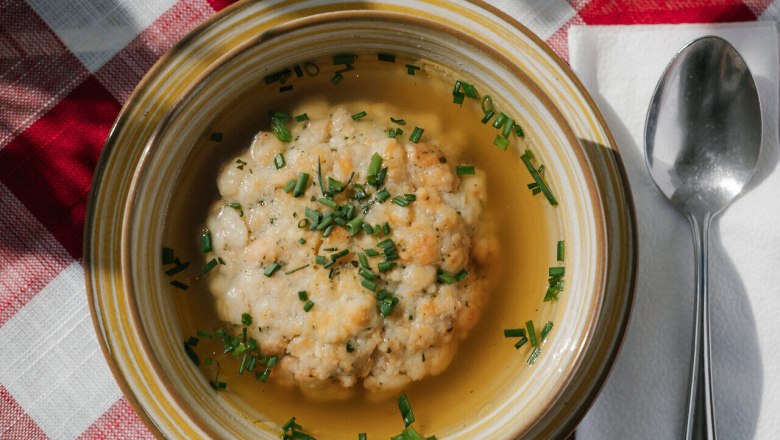 Damböckhaus, Schneeberg, hut, Schneebergland, Vienna Alps in Lower Austria, © Wiener Alpen/Sophie Menegaldo Clear soup with semolina dumplings on a plate on a checkered tablecloth at the Damböckhaus on Schneeberg