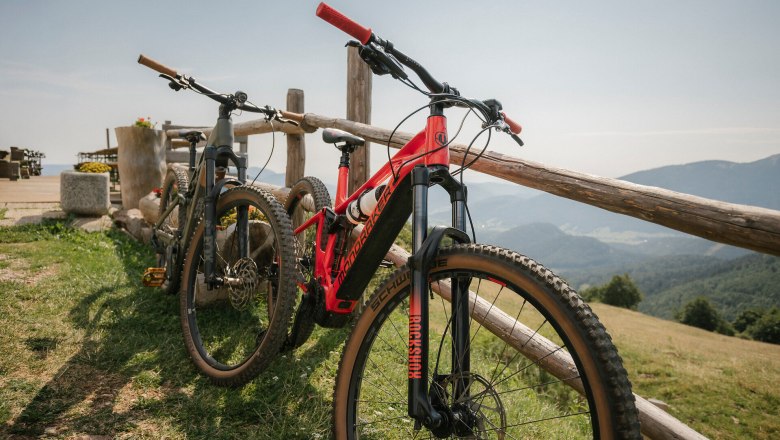 Almreserlhaus, Schneeberg, hut, Schneebergland, Vienna Alps in Lower Austria, © Wiener Alpen/Sophie Menegaldo Mountain bikes leaning against a wooden fence with a panoramic view at the Almreserlhaus on the Schneeberg
