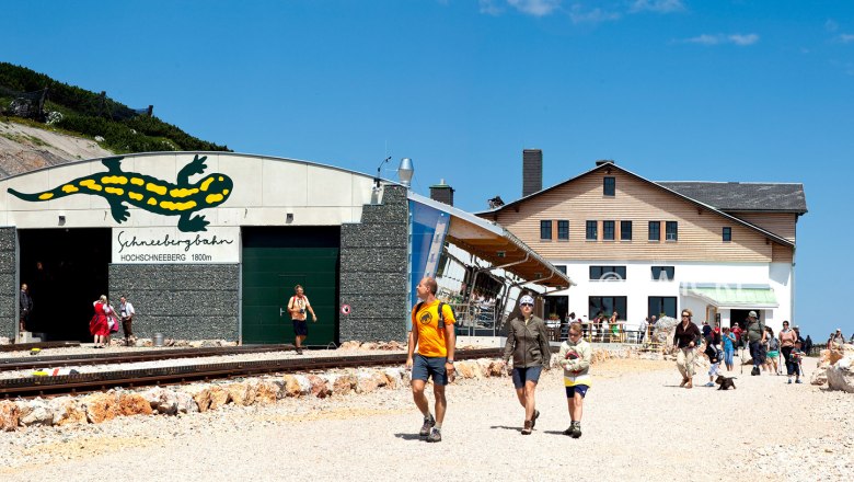 Hochschneeberg mountain lodge, © Niederösterreichische Schneebergbahn GmbH, Foto Franz Zwickl Entrance to the Schneebergbahn on the Hochschneeberg with people and mountain lodge in the background.