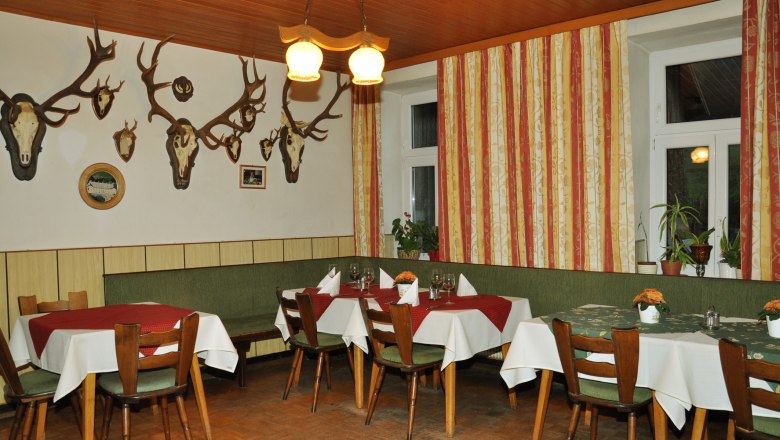 Krumböckhof Inn, © Claudia Alber Interior view of a traditional inn with wooden furniture and antlers on the wall.