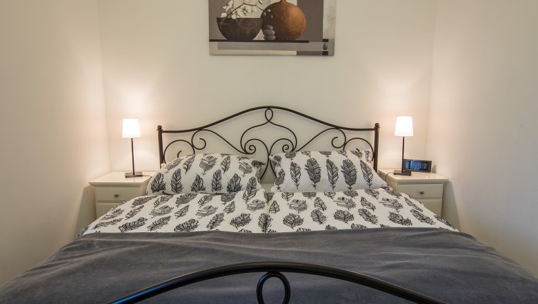 Ferienwohnung, © A. Dirnbauer Schlafzimmer mit Doppelbett, zwei Nachttischen und Lampen.