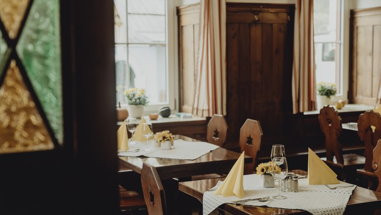 Stroll into the Vienna Alps, © Niederösterreich Werbung/Sophie Menegaldo Cozy restaurant with wooden furniture and laid tables.
