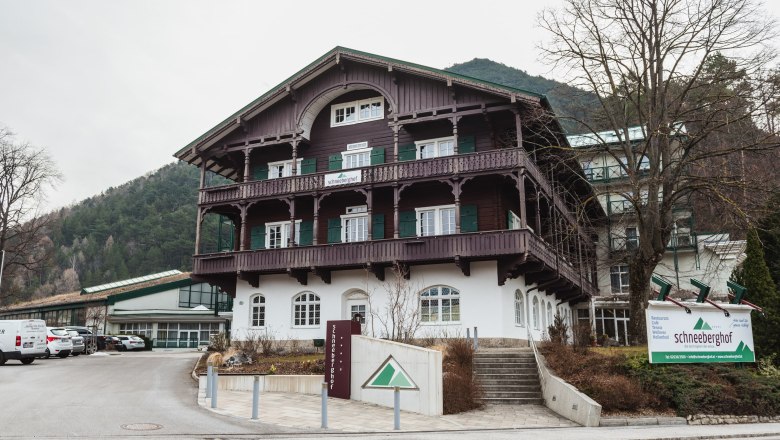 Schneeberghof Hotel, © Hotel Schneeberghof Hotel Schneeberghof in a mountainous setting with traditional architecture and a large sign in front of the building.