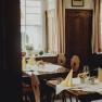 Cozy restaurant with wooden furniture and laid tables.