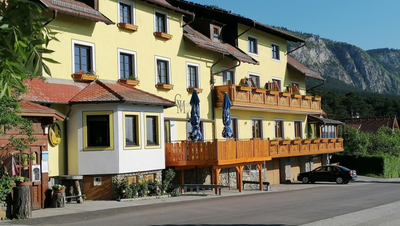 Mohr Inn, © Harald Mohr Yellow inn with wooden balconies and a mountain in the background.