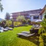 Garten mit Liegen vor dem rosa Haus