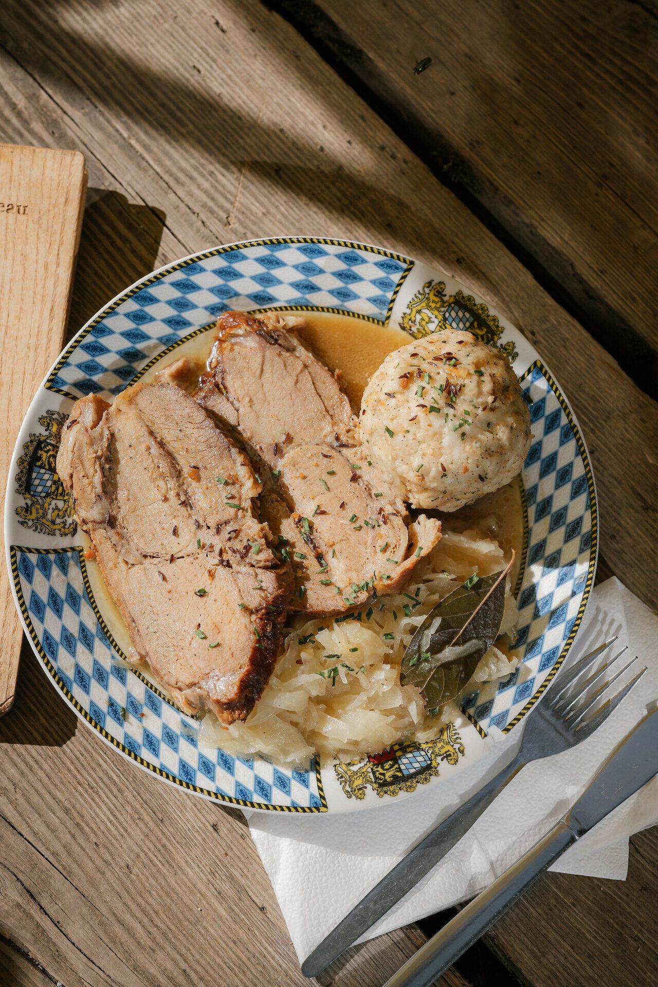 Schweinsbraten mit Sauerkraut und Semmelknödel auf einem Teller in der Edelweißhütte am Schneeberg
