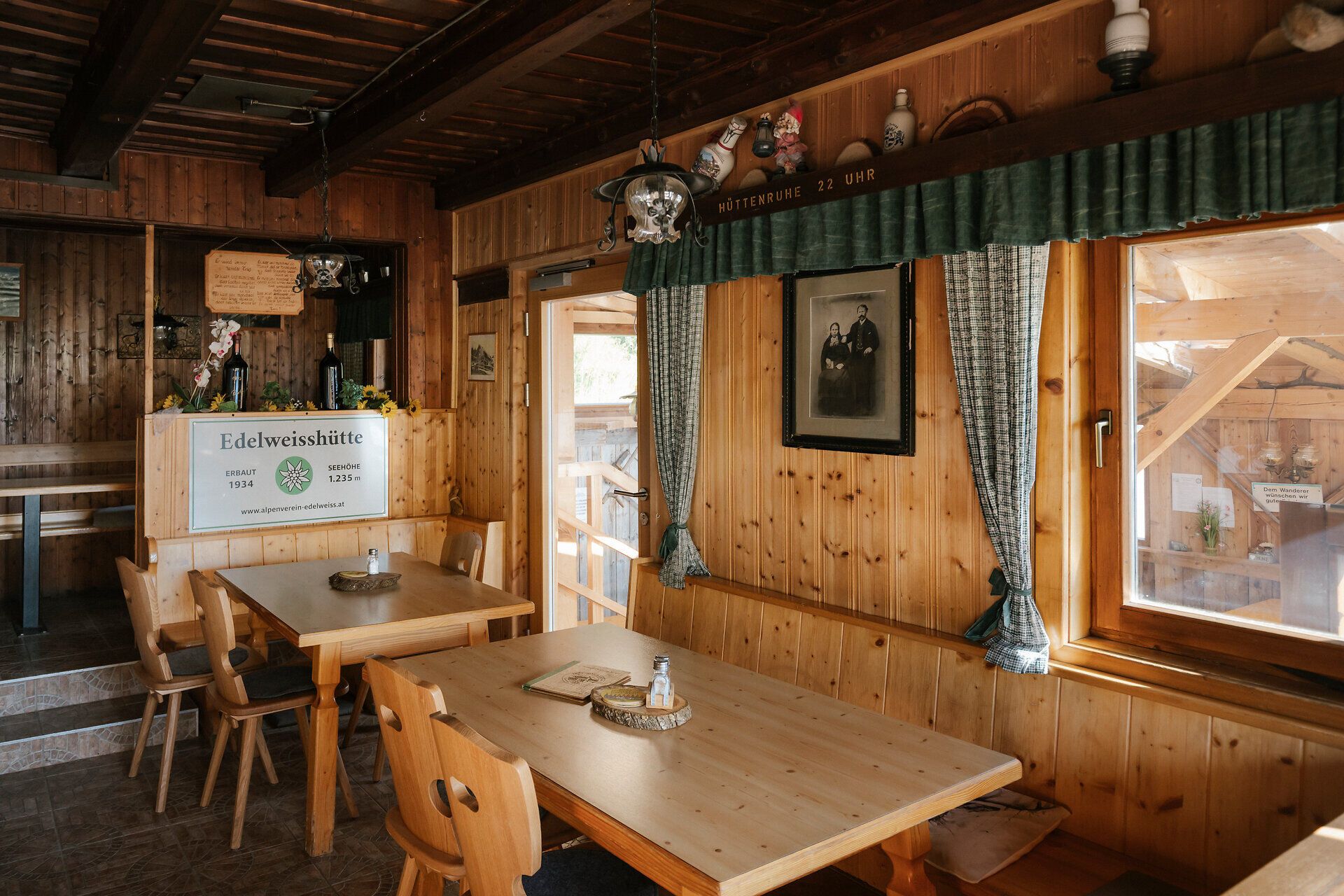 Rustikaler Gastraum mit Holztischen in der Edelweißhütte am Schneeberg