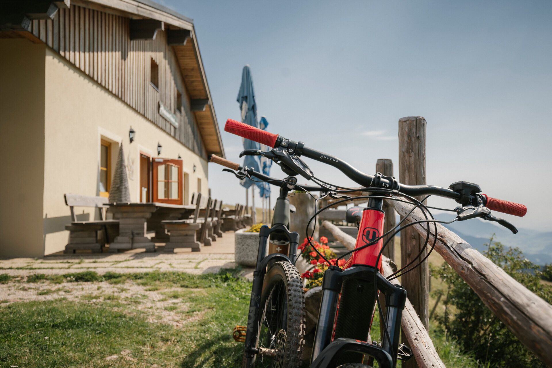 Mountainbike vor dem Almreserlhaus am Schneeberg mit Sitzbänken im Hintergrund
