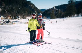 2 Kinder bei einer Schleppliftfahrt