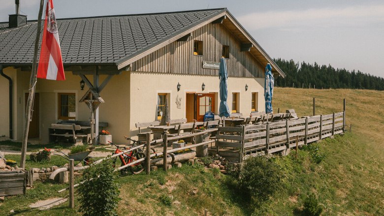 Almreserlhaus, Schneeberg, hut, Schneebergland, Vienna Alps in Lower Austria, © Wiener Alpen/Sophie Menegaldo Exterior view of the Almreserlhaus on the Schneeberg, featuring a terrace and a flagpole