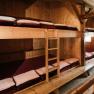 Dormitory-style accommodations in the fishing cabin on Schneeberg, with simple wooden bunk beds