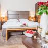 Doppelzimmer im Hotel Schneeberghof mit Bett, Rosen, Sekt und Erdbeeren.