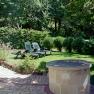 Garden with sun loungers and fountain on a meadow.