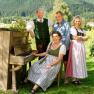 Host family Schmirl in front of the wooden piano in the garden
