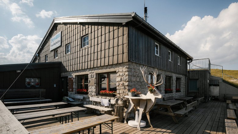 Fisherman's Cabin, Schneeberg, Hut, Schneebergland, Vienna Alps in Lower Austria, © Wiener Alpen/Sophie Menegaldo A fisherman's cabin on Schneeberg with a terrace, benches, and a decorative ibex statue in front of the building