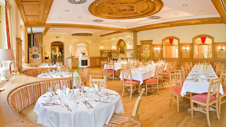 Eleganter Festsaal mit gedeckten Tischen und Holzeinrichtung.