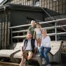 A family is sitting on a wooden bench in front of the fisherman's cabin on Schneeberg
