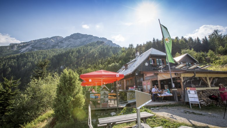 Edelweißhütte am Schneeberg mit Sonnenschirmen und Bergkulisse.