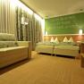 Cozy guest room with double bed, sofa and decorative curtains.