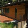 A wooden holiday home with terrace in a green, wooded setting.