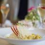 A plate with rice, apple slices and a garnish on a laid table.