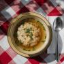 Clear soup with semolina dumplings on a plate on a checkered tablecloth at the Damb&ouml;ckhaus on Schneeberg