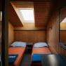 Twin room with a skylight and wood paneling at the Damb&ouml;ckhaus on Schneeberg