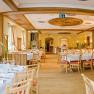 Eleganter Speisesaal mit gedeckten Tischen und Holzverkleidung.