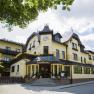 Yellow inn with flowers and blue sky.