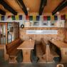 Cozy dining room at the Fischerh&uuml;tte on Schneeberg, featuring wooden tables, benches, and traditional decor