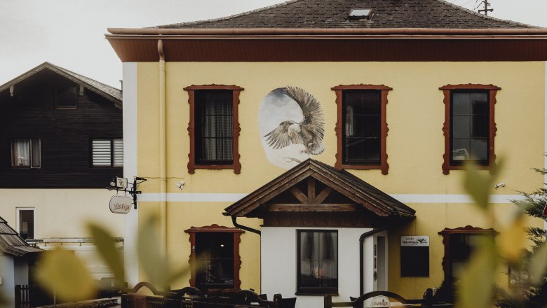 Black Eagle Inn, © Niederösterreich Werbung/Sophie Menegaldo Yellow building with a mural of an eagle and red window frames.