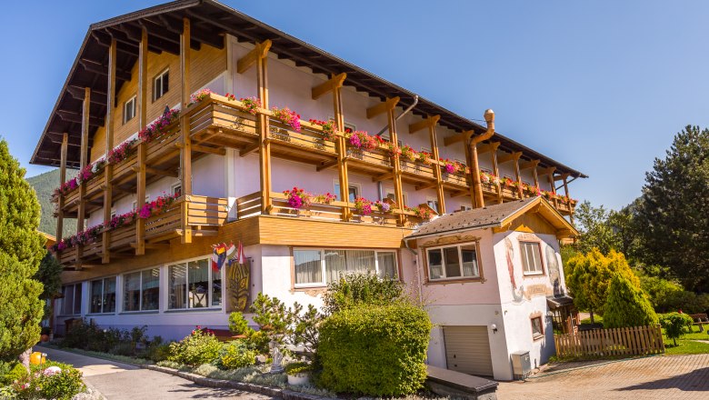 Paradiesquelle rosa Hausansicht mit Holzbalkone