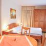 Small apartment with wooden furniture, bed, table and wardrobe.