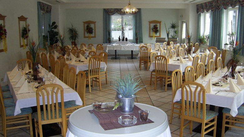 Eleganter Speisesaal mit gedeckten Tischen und Holzst&uuml;hlen.