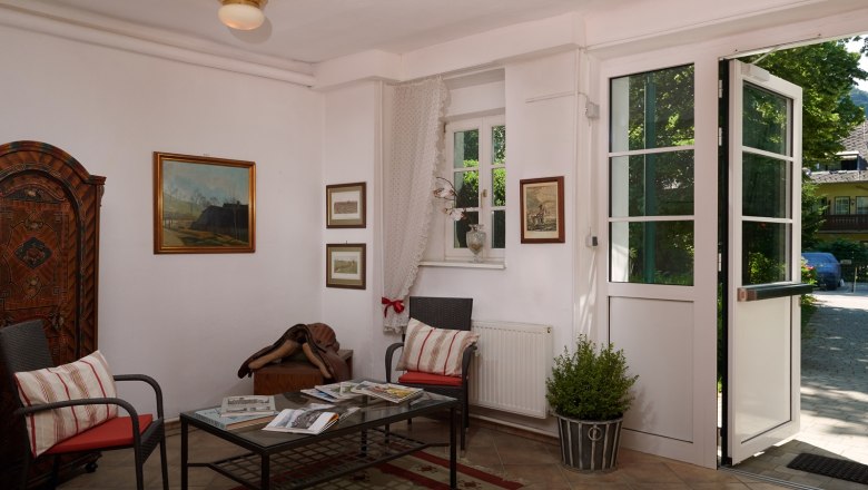 Gem&uuml;tlicher Eingangsbereich mit Sesseln, Tisch und Dekorationen im Landhausstil.