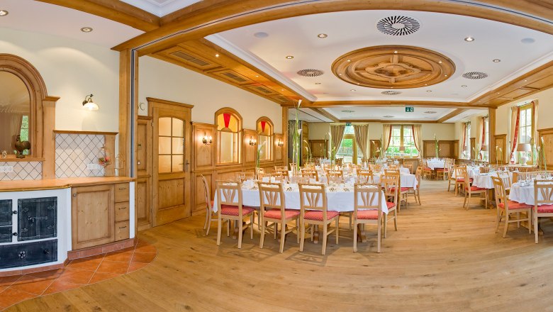 Eleganter, holzverkleideter Speisesaal mit gedeckten Tischen und gro&szlig;en Fenstern.